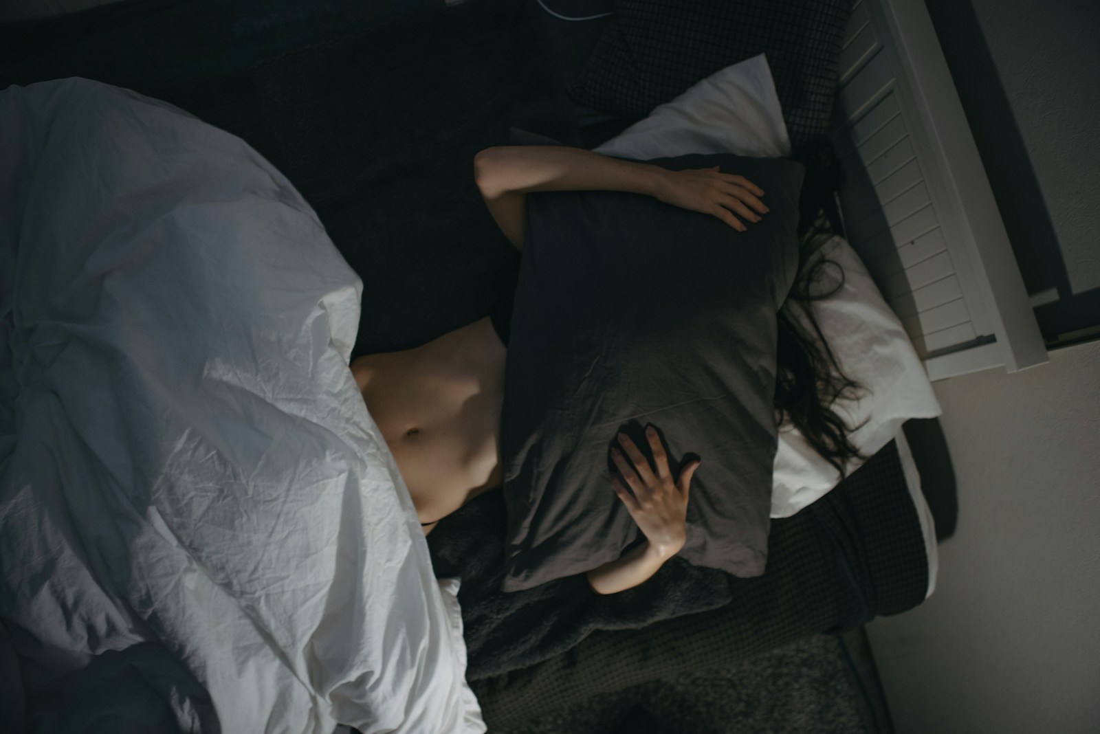 Persona incómoda en la cama con una almohada