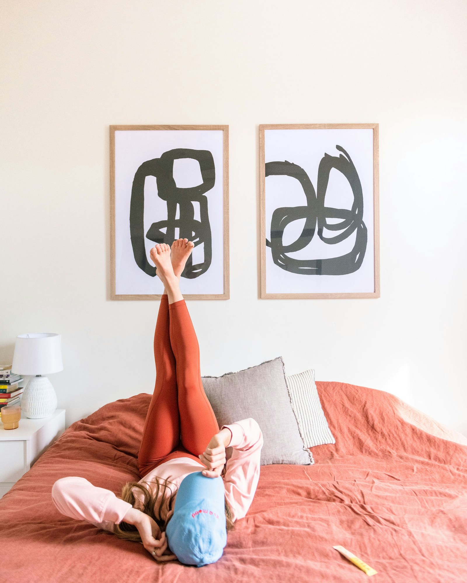 Persona relajándose sobre una cama en un dormitorio acogedor