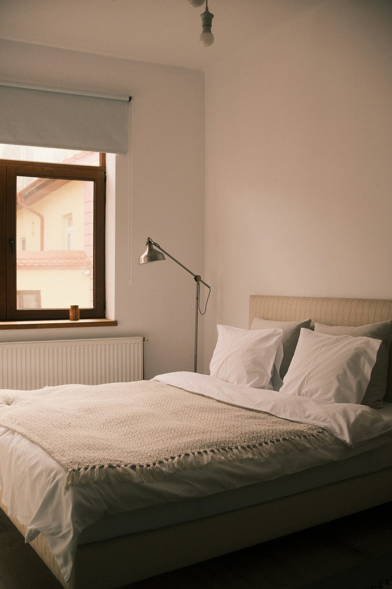 Cama con ropa de cama ligera y luz natural