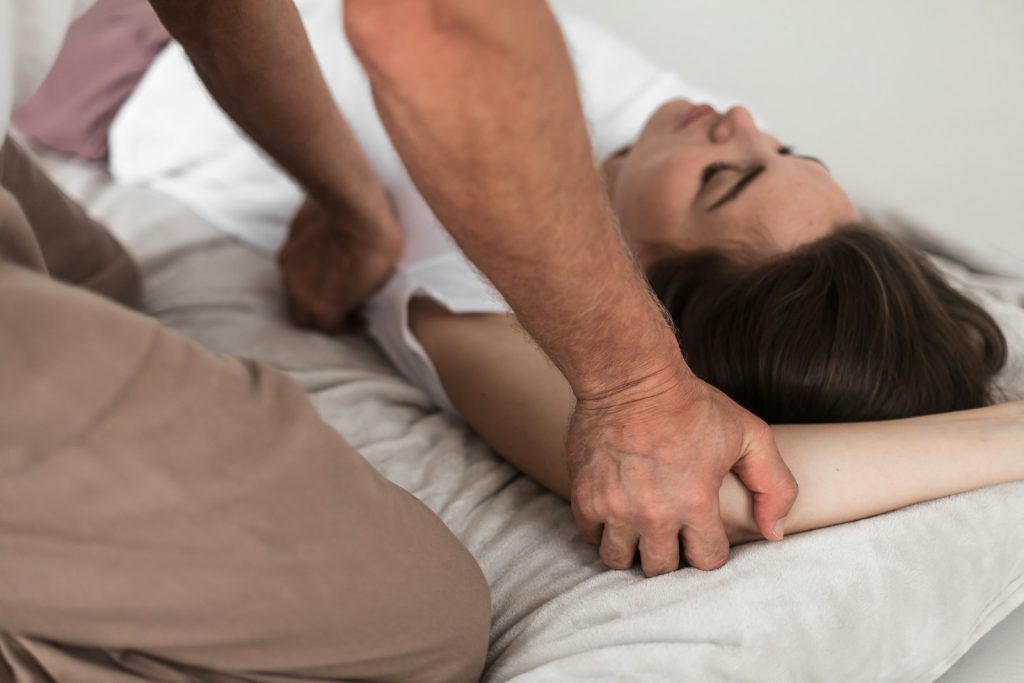 Persona tumbada mientras se ajusta su postura sobre la cama